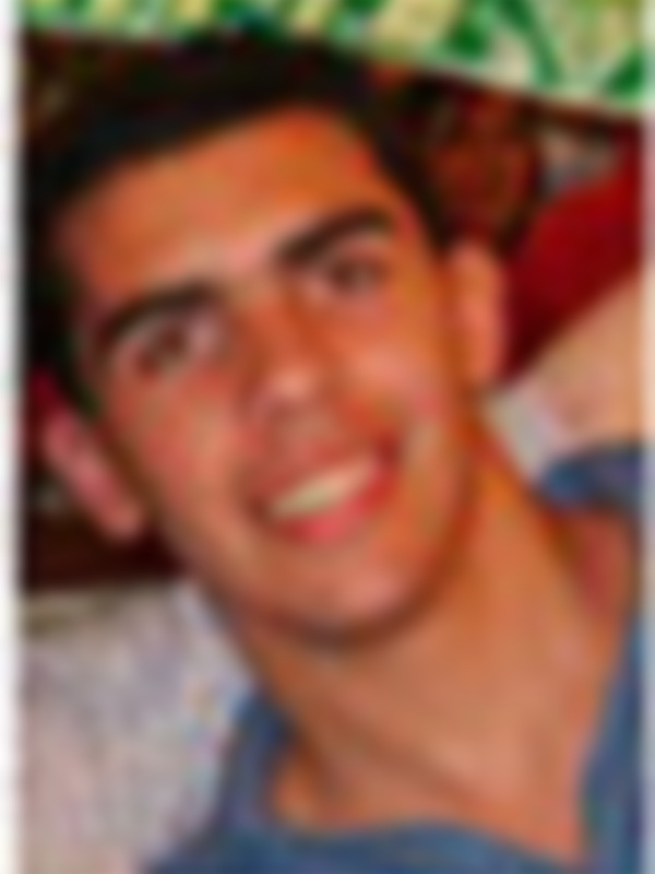 Un hombre joven con una camisa blanca y una camisa de manga larga negra.