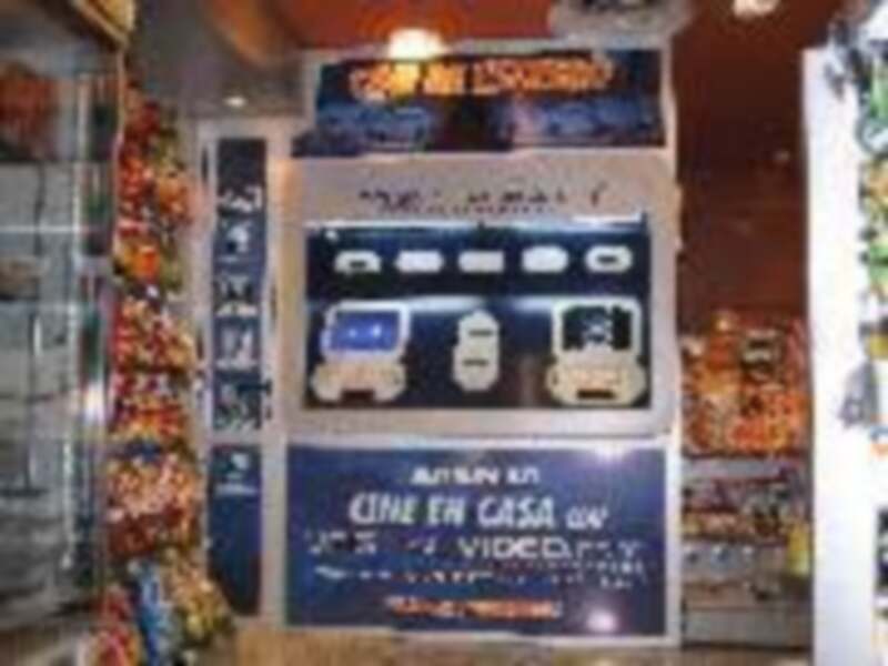 Un mostrador de una tienda de comida rápida con menús en español y imágenes de carritos de comida.