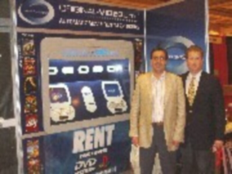 Dos personas en trajes posan frente a un cartel de la película 'Kent'.