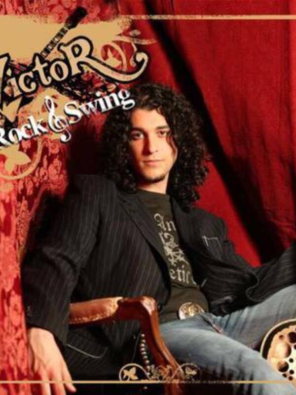 Un hombre con una camiseta negra y jeans se sienta en un sillón, sostiene una guitarra eléctrica y mira hacia la cámara. El fondo es rojo con un diseño floral dorado. En la parte superior de la imagen, hay texto que dice "Victor Rock Swing".
