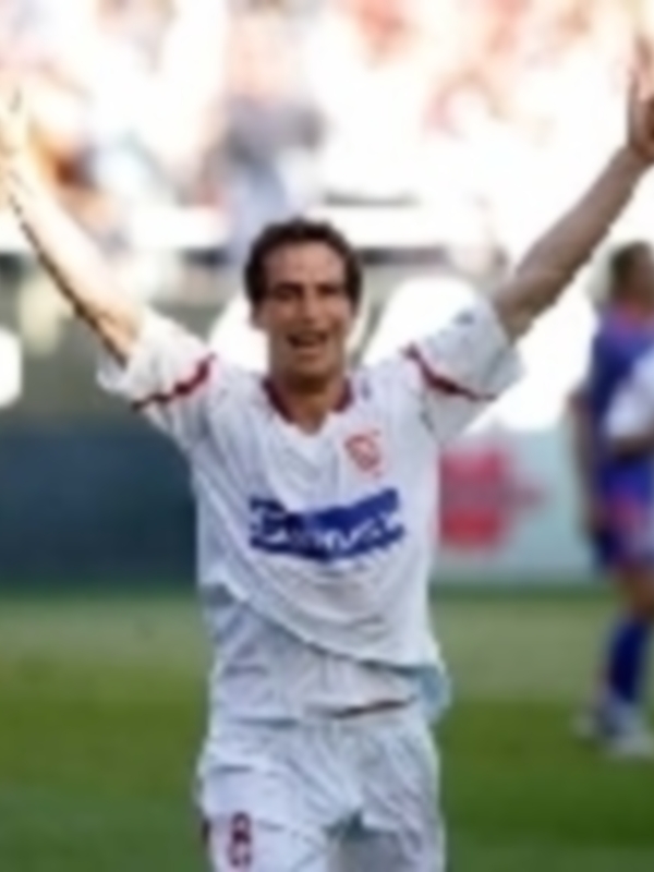 Jugador levantando el puño en celebración durante un partido de fútbol.