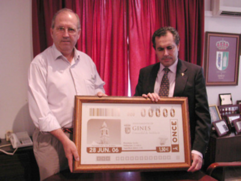 Dos hombres sostienen un certificado de Guinness World Record. La fecha es 26 junio, 2006. El certificado muestra detalles de la categoría 'Once' y un logotipo de la marca Guinness.