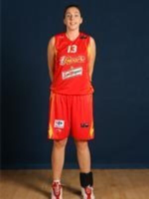 Un jugador de baloncesto vestido con una camiseta roja y pantalones cortos, posando para la foto.