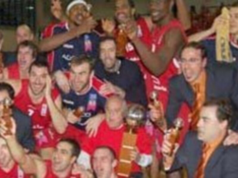 Grupo de personas celebrando con cervezas y copas, posiblemente en un evento deportivo o festivo.