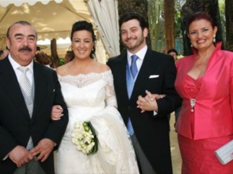 Boda: Novia con ramo y padrinos en trajes formales bajo un toldo blanco.