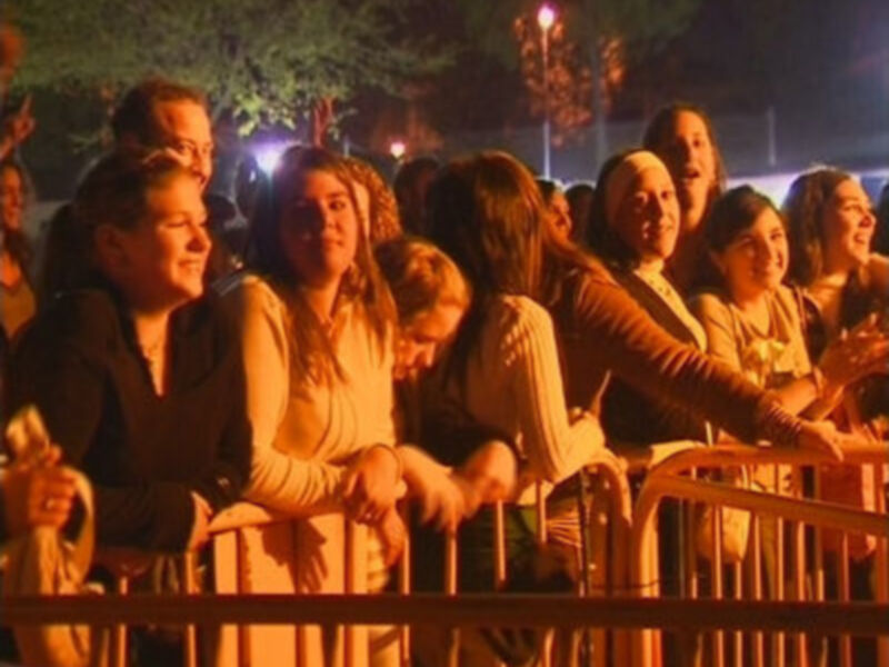 Un grupo de personas disfrutando de una noche de fiesta, con luces brillantes y un ambiente festivo.