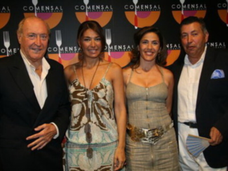 Los cuatro personajes están posando frente a un fondo con el logo de "Comensal" repetido.