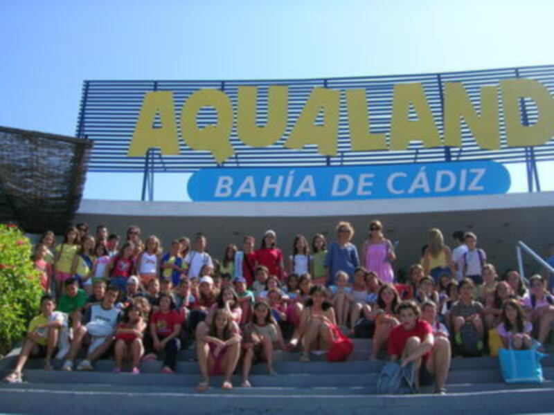 Fotografía de una gran cantidad de personas posando frente a un edificio con la inscripción 'Aqualand' y 'Bahía de Cádiz'.