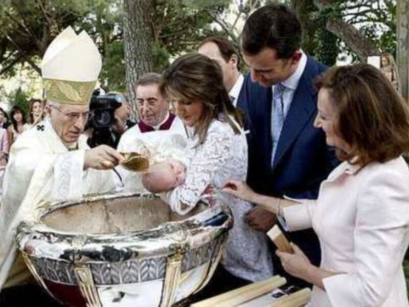 Bautismo en una iglesia, con un sacerdote bendiciendo a un niño recién bautizado, rodeado de familiares y amigos.