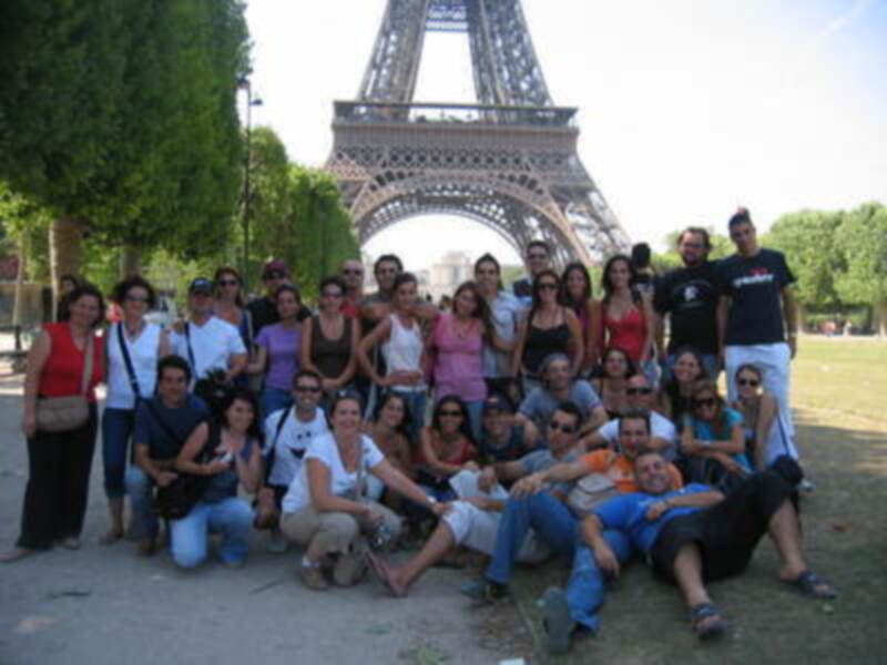 Gruppo de personas frente a la Torre Eiffel en París.