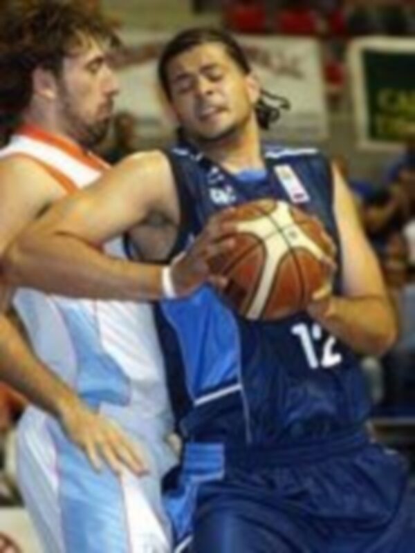 Dos jugadores de baloncesto en acción, uno con una camiseta blanca y otro con azul, luchando por el balón.