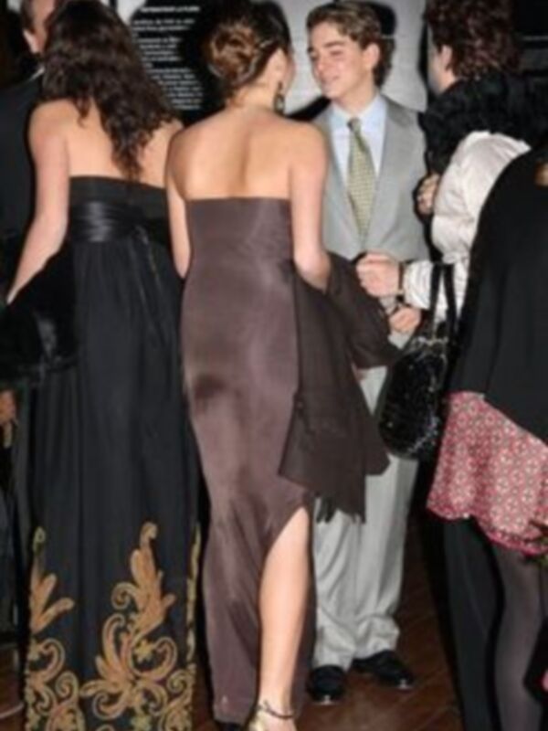 Una noche de gala con vestidos elegantes y una conversación entre amigos en el fondo.