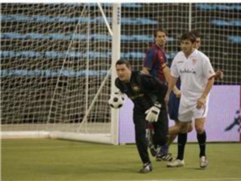 Un portero en acción durante un partido de fútbol, protegiendo la portería.