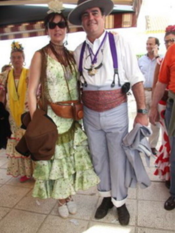 Fiesta tradicional con pareja vestida de traje regional en un evento cultural.
