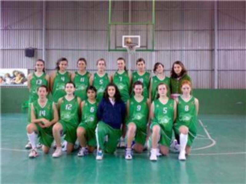 Equipo de baloncesto en verde con números en el vestuario, posiblemente antes de un partido o entrenamiento.