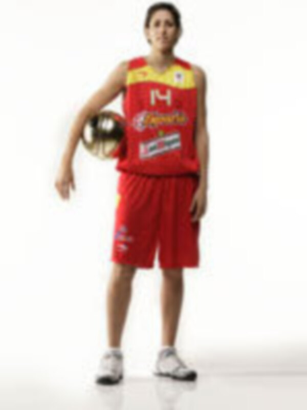 Un jugador de baloncesto con una camiseta roja y un balón en la mano, posando para la foto.