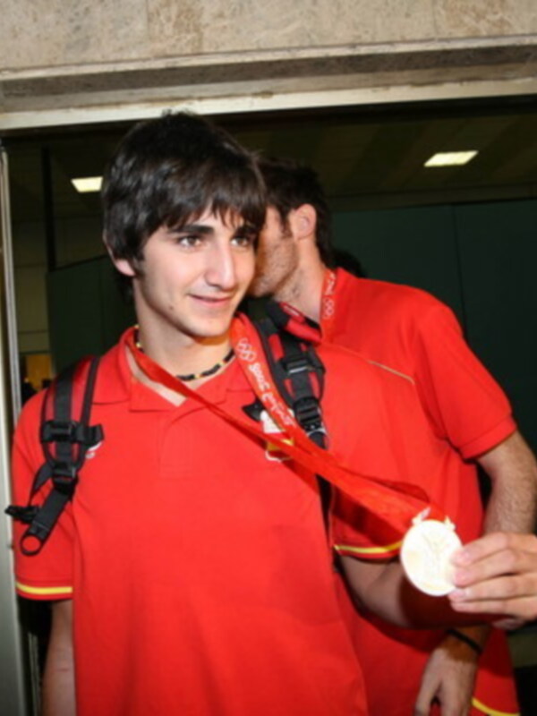 Atleta español con medalla de plata en el cuello, celebrando en el aeropuerto.