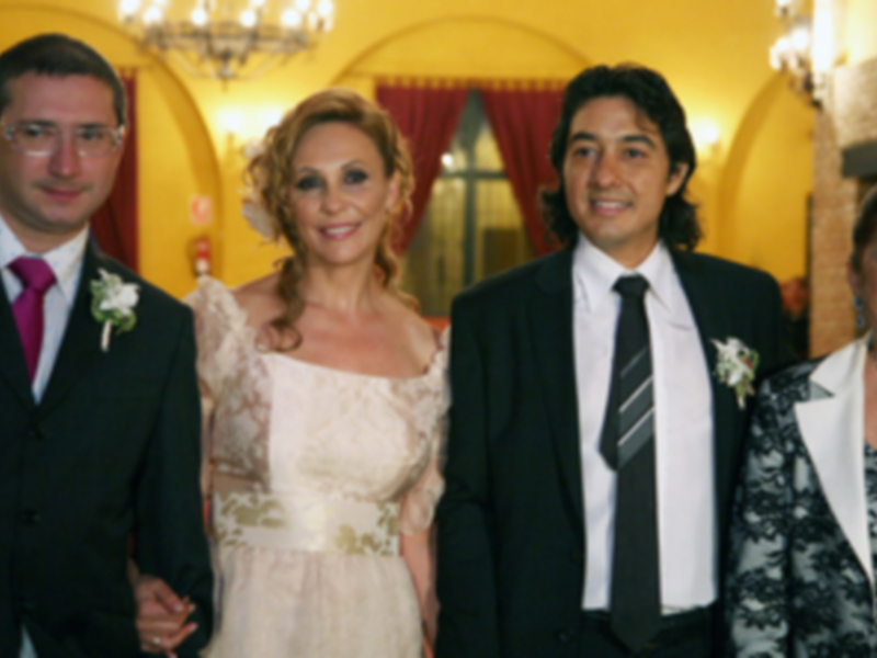 Retrato familiar en una celebración formal, con vestimenta elegante y expresiones sonrientes.