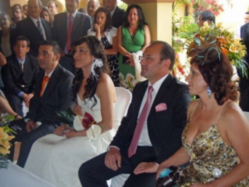 Casamiento en una ceremonia al aire libre con invitados en trajes y vestidos formales.