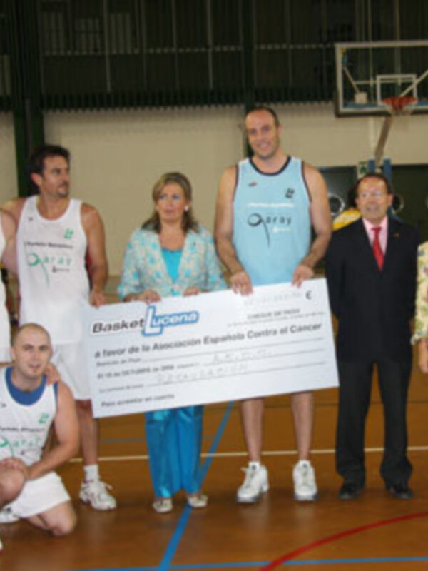 Entrega de un cheque por el 4º Torneo de la Asociación Española contra el Cáncer en un partido de baloncesto.
