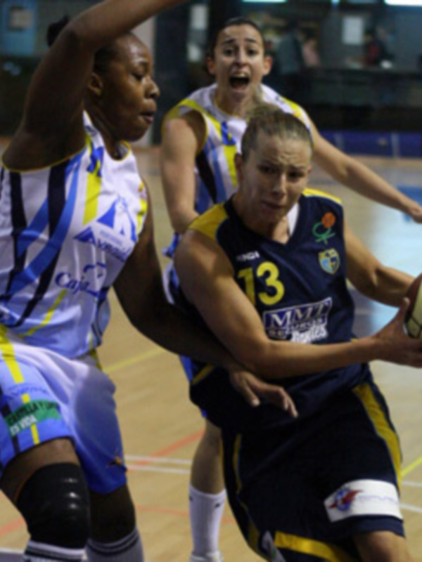 Jugadores de baloncesto en acción durante un partido, con una jugadora en el centro con el número 13 y otra jugadora en el fondo con una camiseta azul y amarilla.