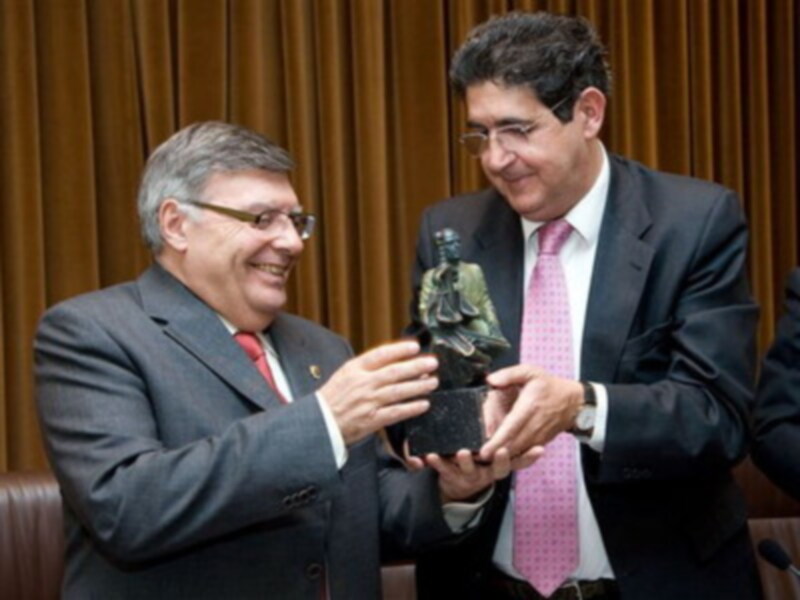 Diplomáticos intercambiando un trofeo en un ambiente formal.