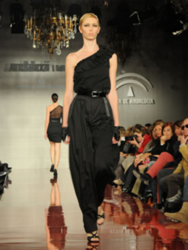 Desfile de moda con modelo caminando por la pasarela en un evento de alta costura.