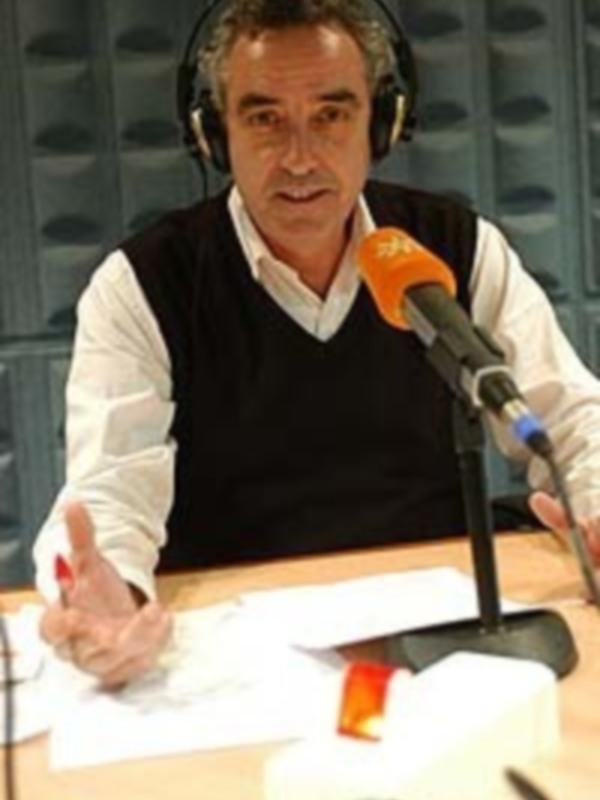 Persona hablando en un estudio de radio, con auriculares y micrófono, aparentemente en plena conversación.