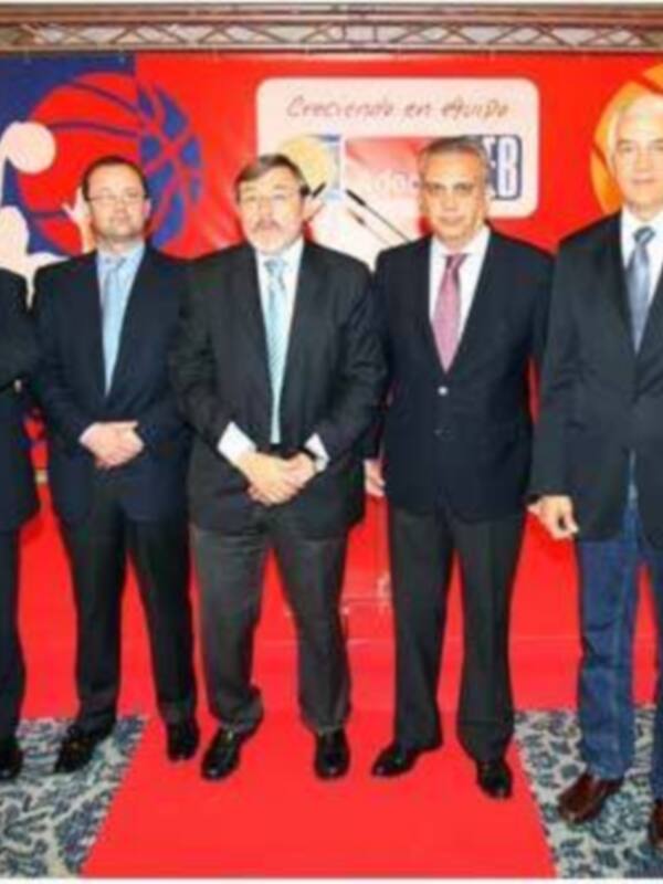 Cumbre empresarial con líderes en trajes formales y fondo de logotipo de empresa.