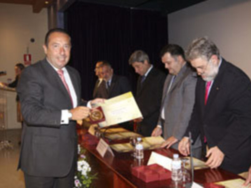 Un grupo de hombres en trajes intercambia documentos en una ceremonia formal.