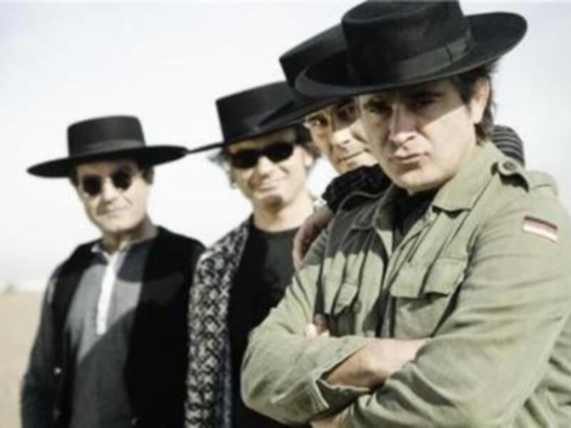 Los músicos de The Byrds posan en el desierto, con sombreros y abrigos de estilo vintage.