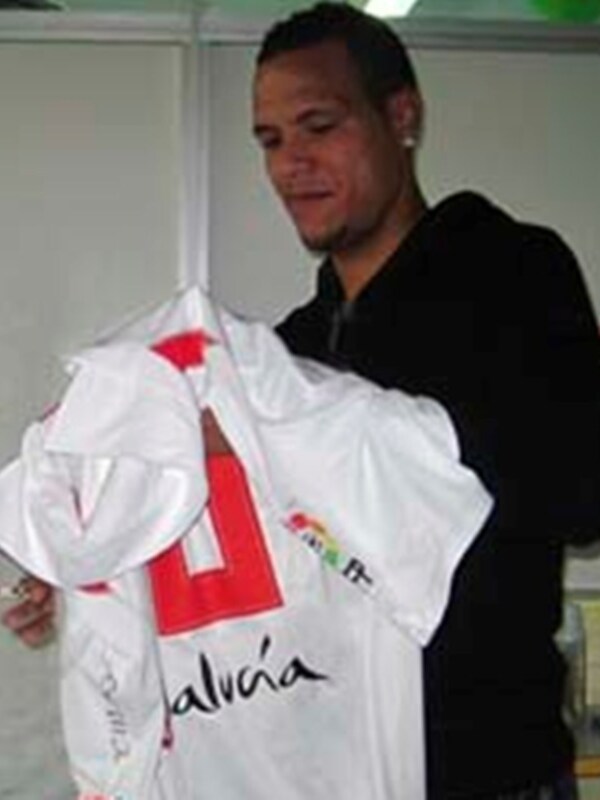Persona sosteniendo una camiseta con el logo de Alvia en un entorno interior.