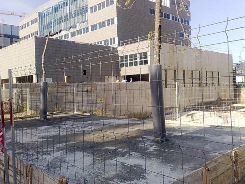 Construcción de un edificio moderno con estructura de acero y muros de hormigón.