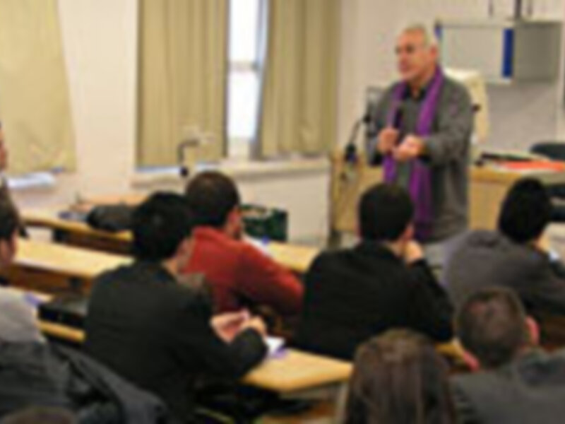 Clase de matemáticas en un aula llena de estudiantes atentos.