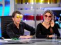 Dos personas sonrientes en un set de televisión, uno con gafas de sol amarillas y la otra con rojas. Detrás, una pantalla con colores brillantes y un monitor en segundo plano.