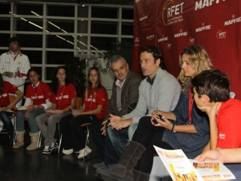 Persona en el centro hablando a un grupo de jóvenes en una reunión de MAPFRE y RFET.