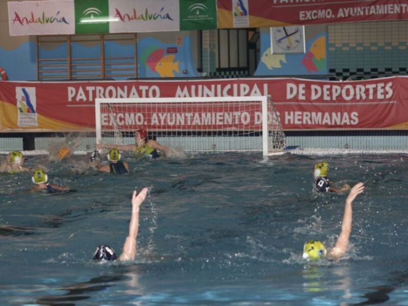 Jugadores de waterpolo en acción durante un partido en una piscina municipal de Andalucía.