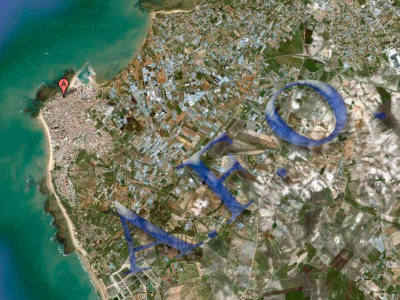Satellite image of a coastal city with blue markings indicating areas of interest or concern.