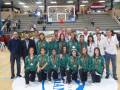 Equipo femenino de baloncesto posando con medallas en un evento deportivo.