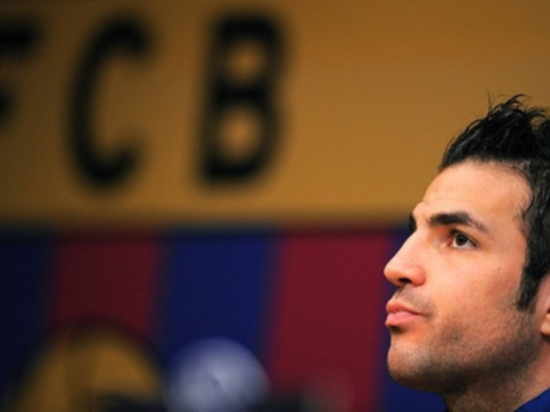 Jugador de fútbol con el escudo del FC Barcelona en el fondo.