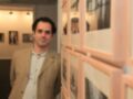 Persona en una exposición de fotografía, rodeada de marcos y obras de arte.