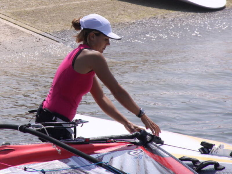 Una mujer en una canoa de remo en el agua.