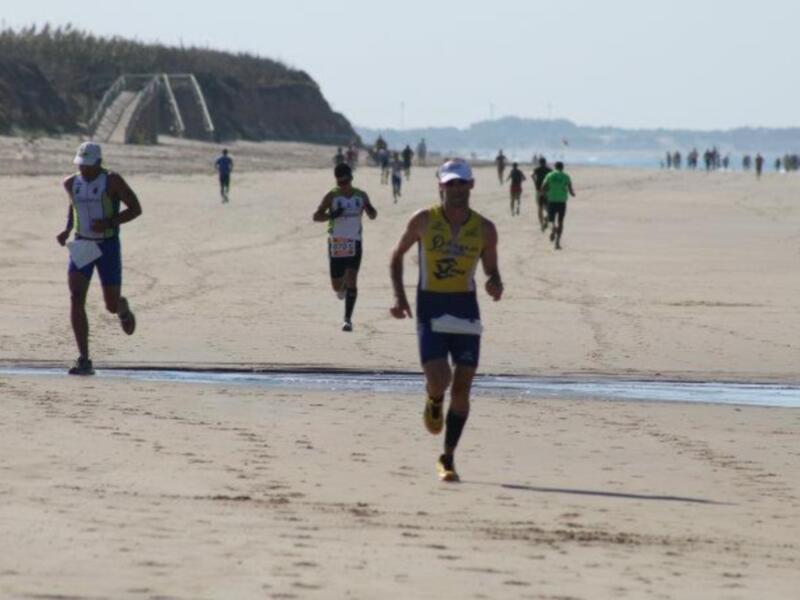Corredores en la playa durante una carrera de triatlón.