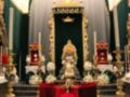 Altar con estatua de la Virgen María en un entorno religioso, adornado con flores y candelabros dorados.