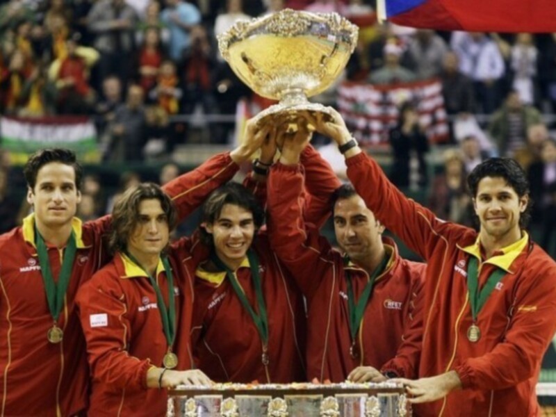 Equipo de tenis celebrando con el trofeo de campeón en un torneo de tenis.