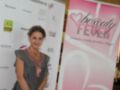 Una mujer sonríe frente a un cartel de "Beauty Fever", evento de belleza blogger en Andalucía.