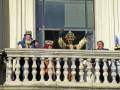 Reyes Magos en el balcón de un palacio, vestidos con trajes tradicionales y coronas.