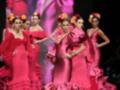 Modelos de vestidos de flamenca en color rosa en una pasarela de moda.