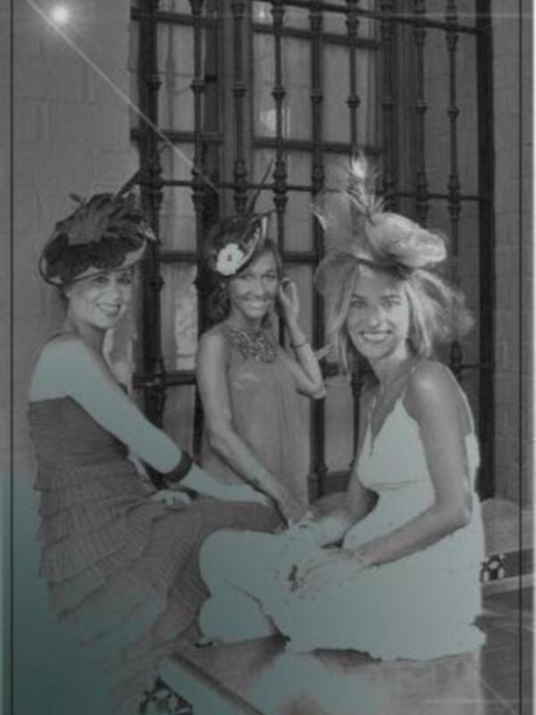 Tres mujeres posan en un ambiente elegante, con sombreros y vestidos de gala. La imagen está firmada "LOLUCAS TOCADOS".