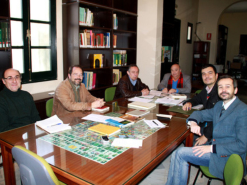 Reunión de trabajo en un entorno profesional con libros y documentos en la mesa.